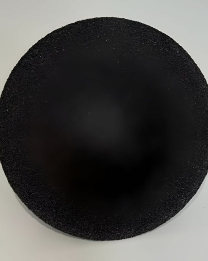 Black circular foam pad on a white background