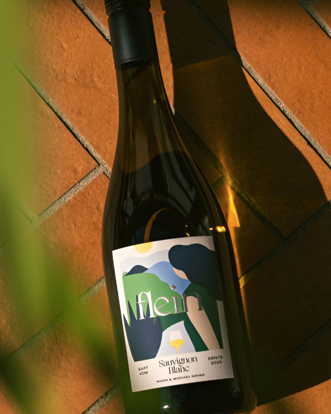 Flein Sauvignon Blanc grape juice bottle placed on a tiled floor in warm sunlight