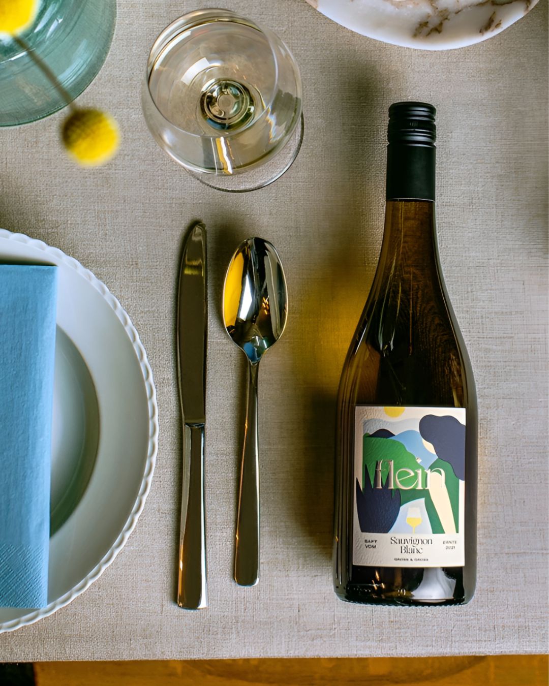 Flein Sauvignon Blanc grape juice bottle placed on a dining table with glassware and cutlery