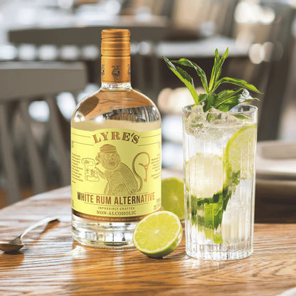 Lyre's White Rum Alternative bottle with a mojito cocktail on a wooden table.